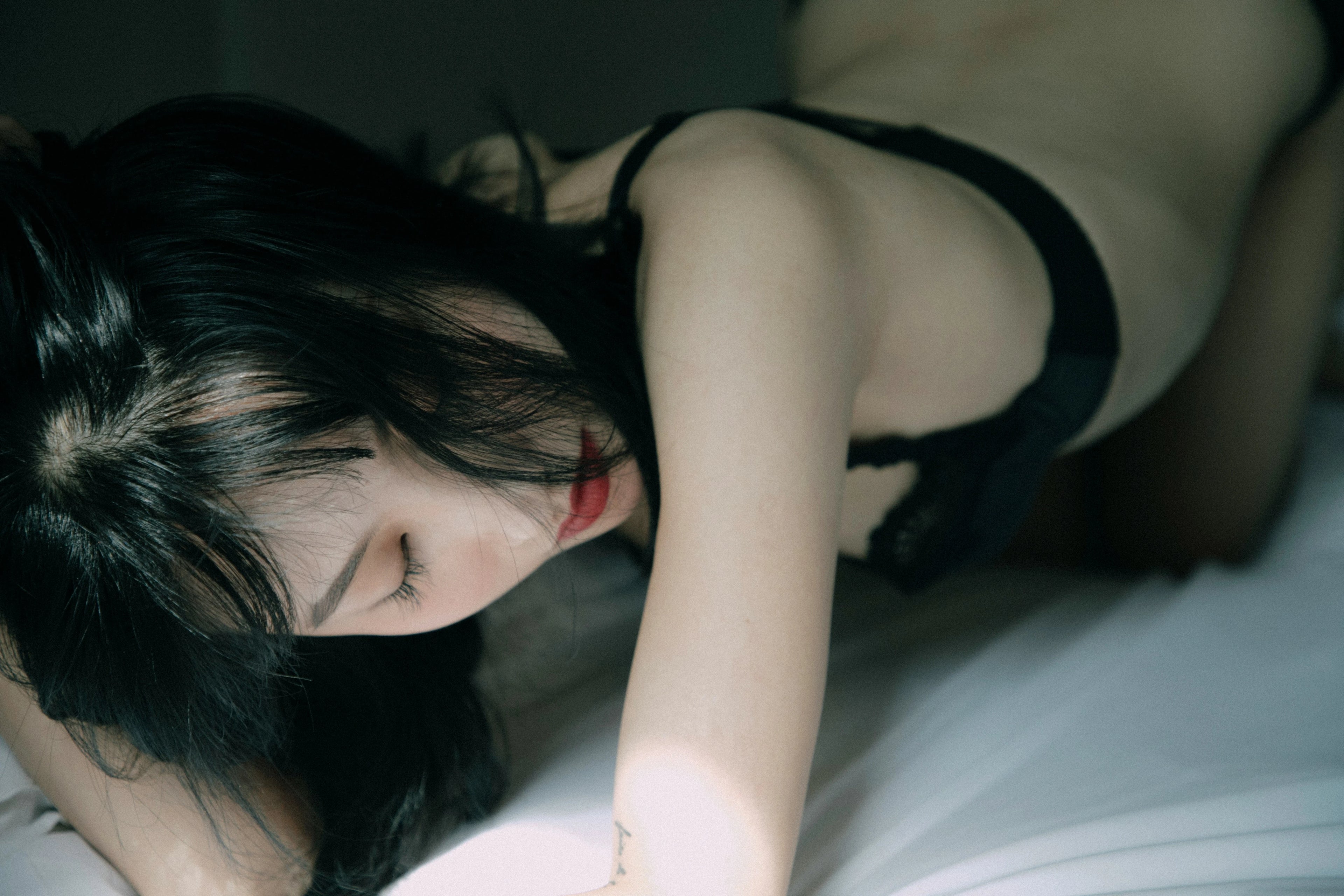 femme sur un lit en soutiens gorges noir